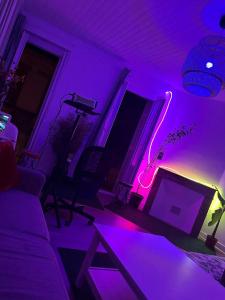 sala de estar con luces moradas y sofá en Un jacuzzi a Bordeaux, en Burdeos
