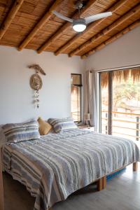 1 dormitorio con 1 cama en una habitación con ventana en Northshore Point Zoritos, en Caleta Grau
