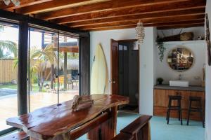 a living room with a wooden table and a surfboard at Northshore Point Zoritos in Caleta Grau
