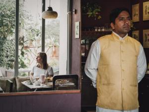 un homme debout devant un restaurant avec une femme dans l'établissement Ekaa Villa near Taj Mahal, à Agra