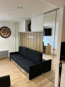 uma sala de estar com um sofá preto num quarto em Studio Contemporain, À Deux Pas de la Mer à La Ciotat ! em La Ciotat