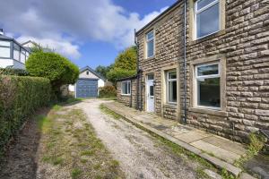 a dirt road next to a brick building at Bar Cottage Number 2 in Altham