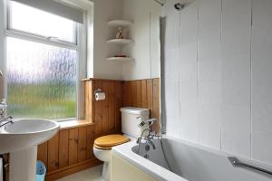 a bathroom with a tub and a toilet and a sink at Bar Cottage Number 2 in Altham