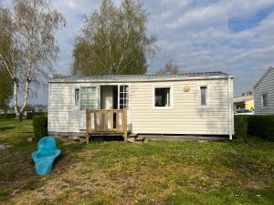 a small white tiny house in a yard at Camping Les Portes de la Baie de Somme in Mareuil-Caubert