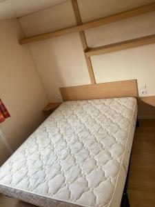 - un lit vide dans une petite pièce dans l'établissement Camping Les Portes de la Baie de Somme, à Mareuil-Caubert