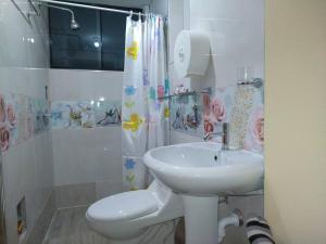 La salle de bains est pourvue d'un lavabo, de toilettes et d'une douche. dans l'établissement Mi hermosa Casita con baño y cocina privados, à Lima