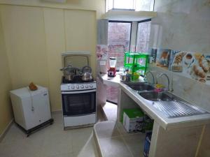 Il comprend une petite cuisine équipée d'une cuisinière et d'un évier. dans l'établissement Mi hermosa Casita con baño y cocina privados, à Lima