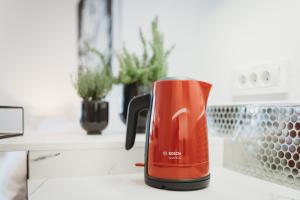 a red coffee pot sitting on a kitchen counter at Romantic JUMP Studio overlooking river, free parking in Ljubljana