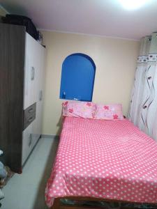 une petite chambre avec un lit rose et une tête de lit bleue dans l'établissement Mi hermosa Casita con baño y cocina privados, à Lima