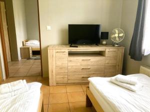 a room with two beds and a television on a dresser at Hotel Ava in Gliwice