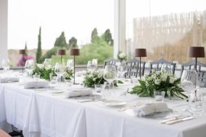 eine Gruppe von Tischen mit weißen Tischdecken und Blumen in der Unterkunft Hotel Canasta in Capri
