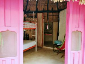 Habitación con puertas rosas, 1 cama y 1 dormitorio. en Aldea Maya Toktli Orígenes: Alberca + Wifi-Starlink + Tour Sustentabilidad, en Izamal