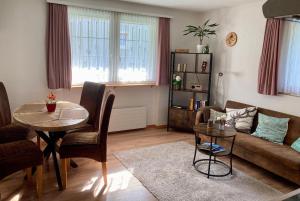 ein Wohnzimmer mit einem Sofa und einem Tisch in der Unterkunft Ferienwohnung Haus am Bach in Toggenburg in Wildhaus
