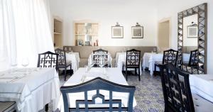 ein Esszimmer mit weißen Tischen und schwarzen Stühlen in der Unterkunft Hotel Canasta in Capri