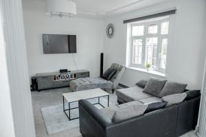 a living room with a couch and a tv at Floral, 5 Bed House in London with Garden, Parking in Dagenham