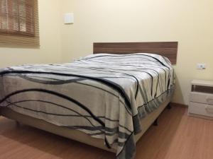 1 cama en un dormitorio con cabecero de madera en POUSADA SuaCasita - 5 LAGOS, en Mairiporã