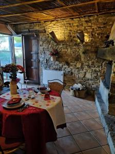 una mesa en una habitación con una pared de piedra en La Cova de Can Pavet, en Pontons