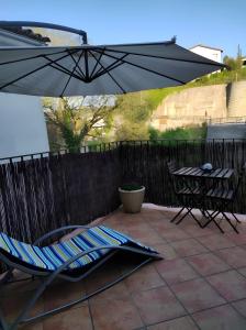 a patio with an umbrella and a chair and a table at La Cova de Can Pavet in Pontons
