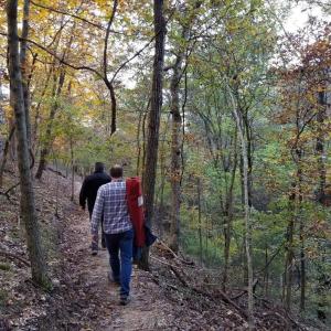 two people walking down a trail in the woods at Loblolly Pines Adventure Log Cabin in Eureka Springs