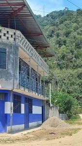 ein blau-weißes Gebäude mit einem Balkon in der Unterkunft ALOJAMIENTO ANY in Tingo María