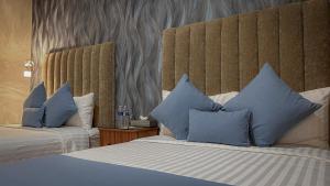 una camera d'albergo con due letti con cuscini blu di ArcoSodi Hotel Boutique a Città di Oaxaca