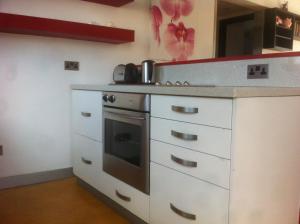 a kitchen with white cabinets and a stove at Sandy Beach Apartment 8 in Voroklini