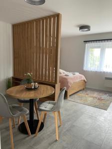 a room with a table and a bed and a bedroom at Martin Apartmanok in Bük