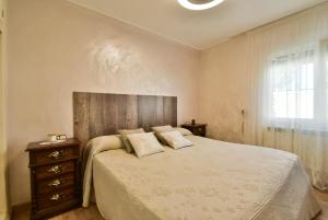 sypialnia z łóżkiem, komodą i oknem w obiekcie Casa CAMPOAMOR w mieście Orihuela