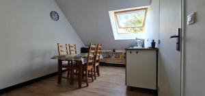 a kitchen with a table and chairs and a window at Chez Julie in Arnage