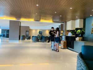two people standing in the lobby of a building at NJ's Place, Shore 1 Residences, MOA Complex, Pasay City, Philippines in Manila