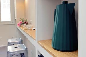 a large green vase sitting on a shelf in a bathroom at Youcomehere - Montebello in Rome