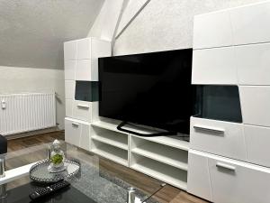 a large white entertainment center with a flat screen tv at Moderne Zentrale FeWo City Retreat in Bullay