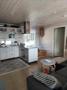 a kitchen and living room with a couch and a table at Kaukuanjärven Kimallus in Kuloharju