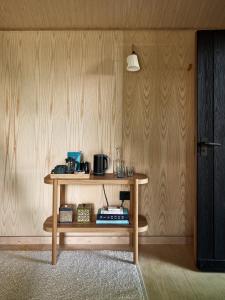 een tafel in een kamer met een houten muur bij Bay House Studio in Bath