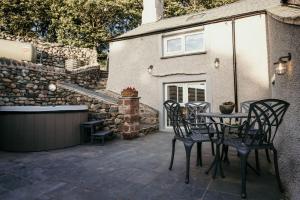 a patio with a table and chairs and a building at Sledbank Cottage in the Hill, Silecroft in Silecroft