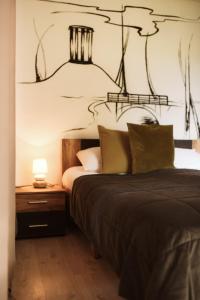 a bedroom with a bed and a lamp on a table at Hillhof 44 in Alūksne +5 photos