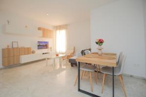 a dining room and living room with a table and chairs at Modern APT next to Old Town - 10m walk Isla Mágica in Seville