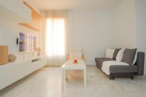 uma sala de estar com um sofá e uma mesa em Modern APT next to Old Town - 10m walk Isla Mágica em Sevilha