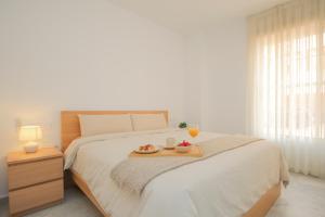 a bedroom with a bed with a tray of food on it at Modern APT next to Old Town - 10m walk Isla Mágica in Seville