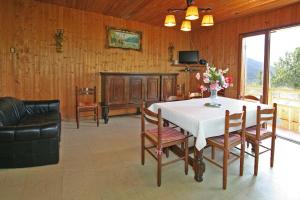 Un comedor con una mesa con un jarrón de flores encima. en Les Jonquilles, en Les Clefs