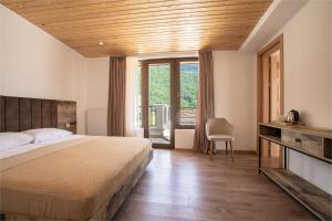 una camera da letto con un letto e una grande finestra di Anne's Hotel in Mestia a Mestia