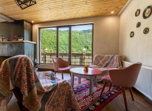 une chambre avec des chaises, une table et une fenêtre dans l'établissement Anne's Hotel in Mestia, à Mestia