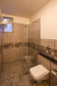 a tiled bathroom with a toilet and a sink at Coastal Pearl Hotel Margao Railway Station in Madgaon