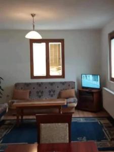 a living room with a couch and a television at Žabljak Apartman in Žabljak