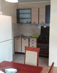 a kitchen with a table and a white refrigerator at Žabljak Apartman in Žabljak