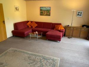 ein Wohnzimmer mit einem roten Sofa und einem Tisch in der Unterkunft Ferienhaus Elbe-Ilenpool in Bleckede
