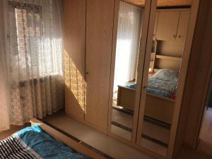 einen Schrank mit einem Spiegel in einem Schlafzimmer in der Unterkunft Ferienhaus Elbe-Ilenpool in Bleckede