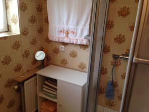 ein kleines Bad mit einem weißen Kühlschrank und einem Fenster in der Unterkunft Ferienhaus Elbe-Ilenpool in Bleckede