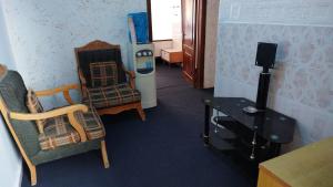 Zimmer mit Stühlen, einem Tisch und einem TV in der Unterkunft City Center Hostel in Gerasa