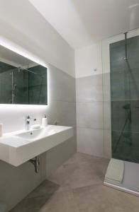 een witte badkamer met een wastafel en een douche bij Sa Pasadina in Àrbatax